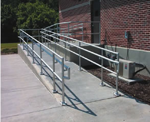 An ramped walkway with aluminum handrails on both sides.